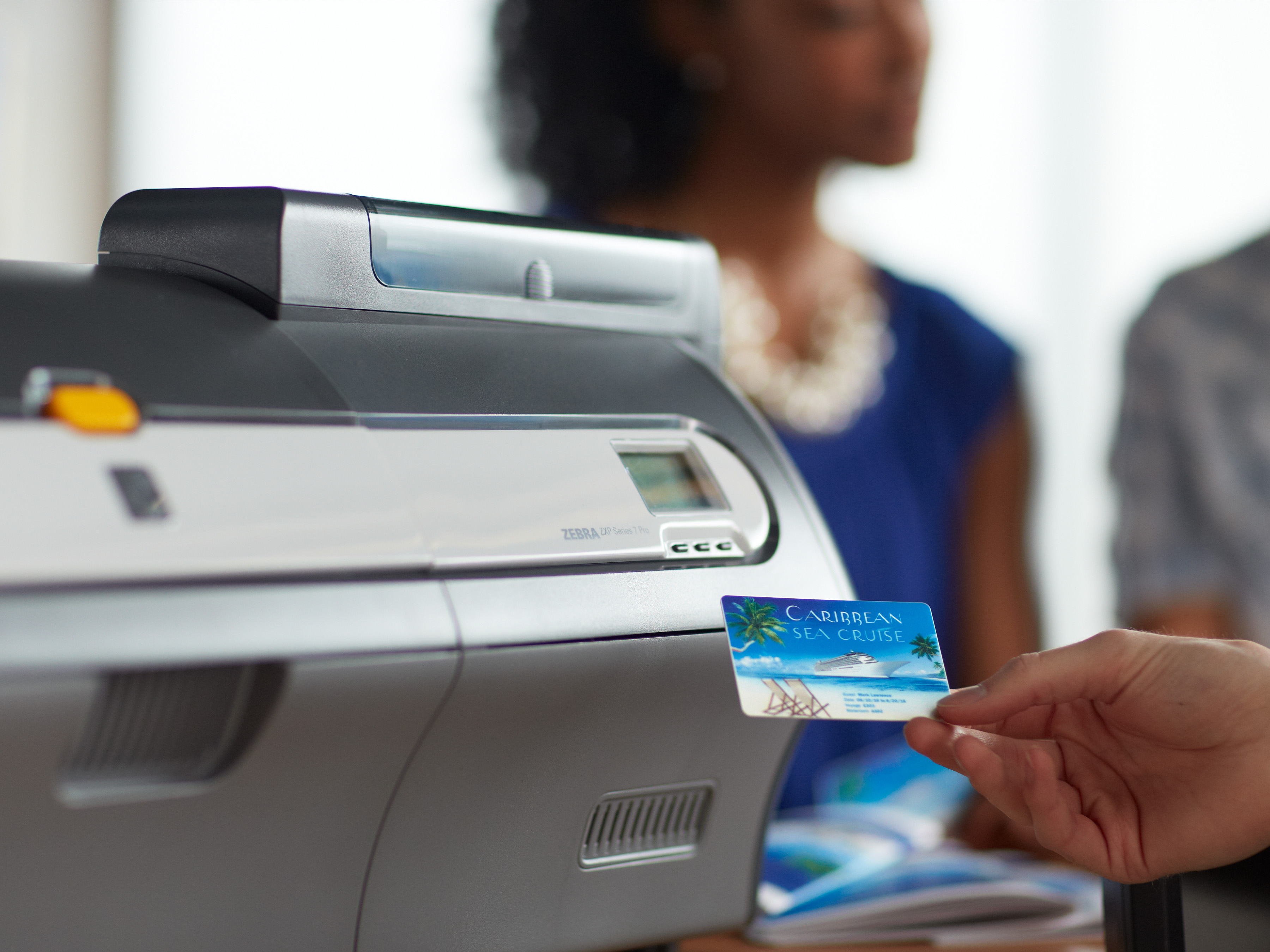 Zebra card printer prints out a Caribbean sea cruise onboard expense account card