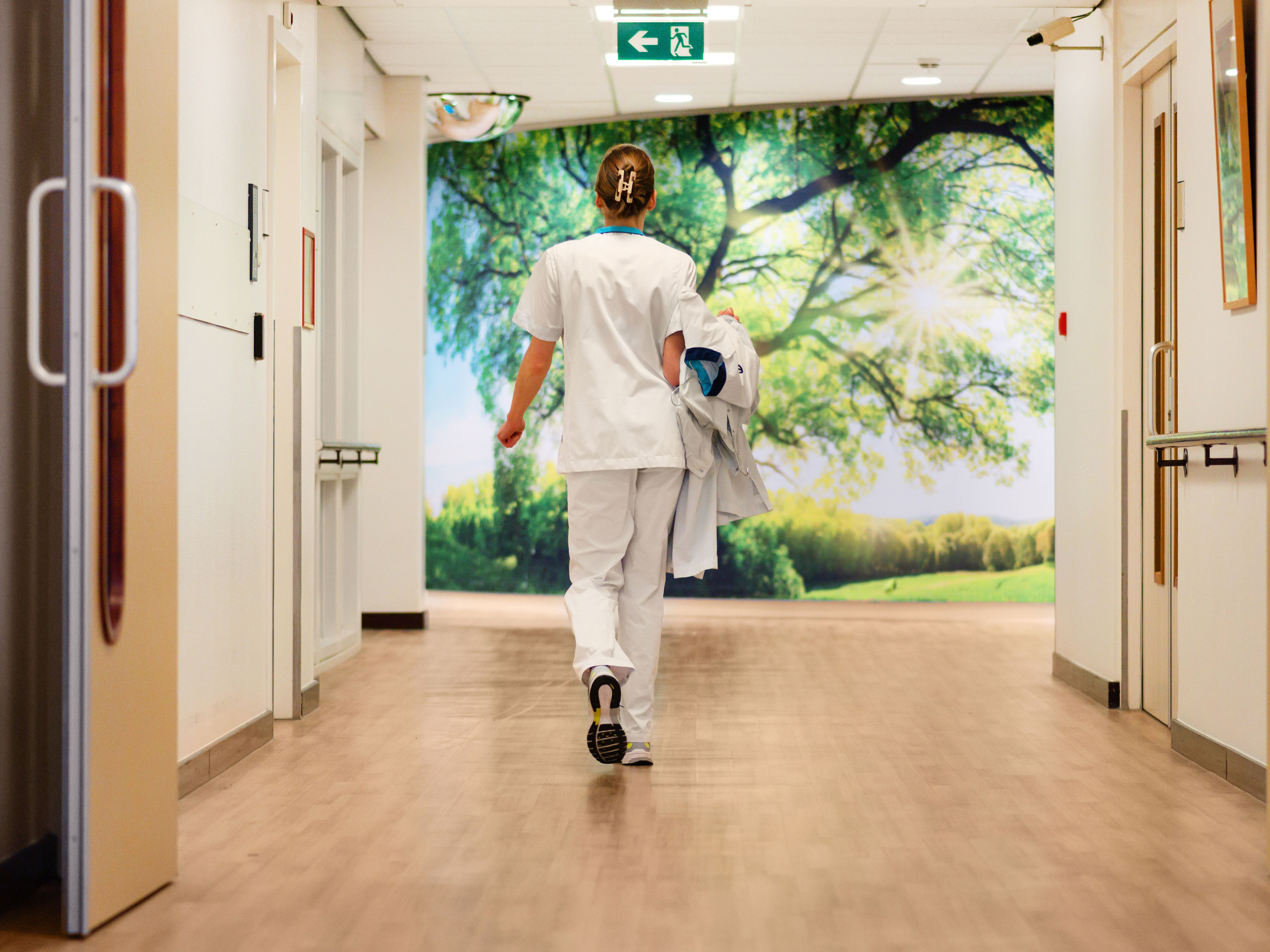Photograph of a nurse walking down a hospital corridor